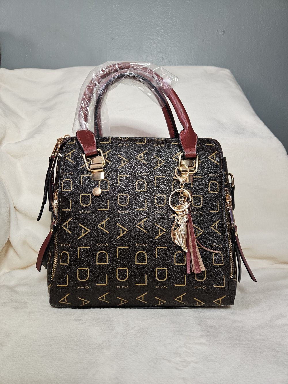 Structured Brown Satchel with Burgundy Handles and Tassel Charm